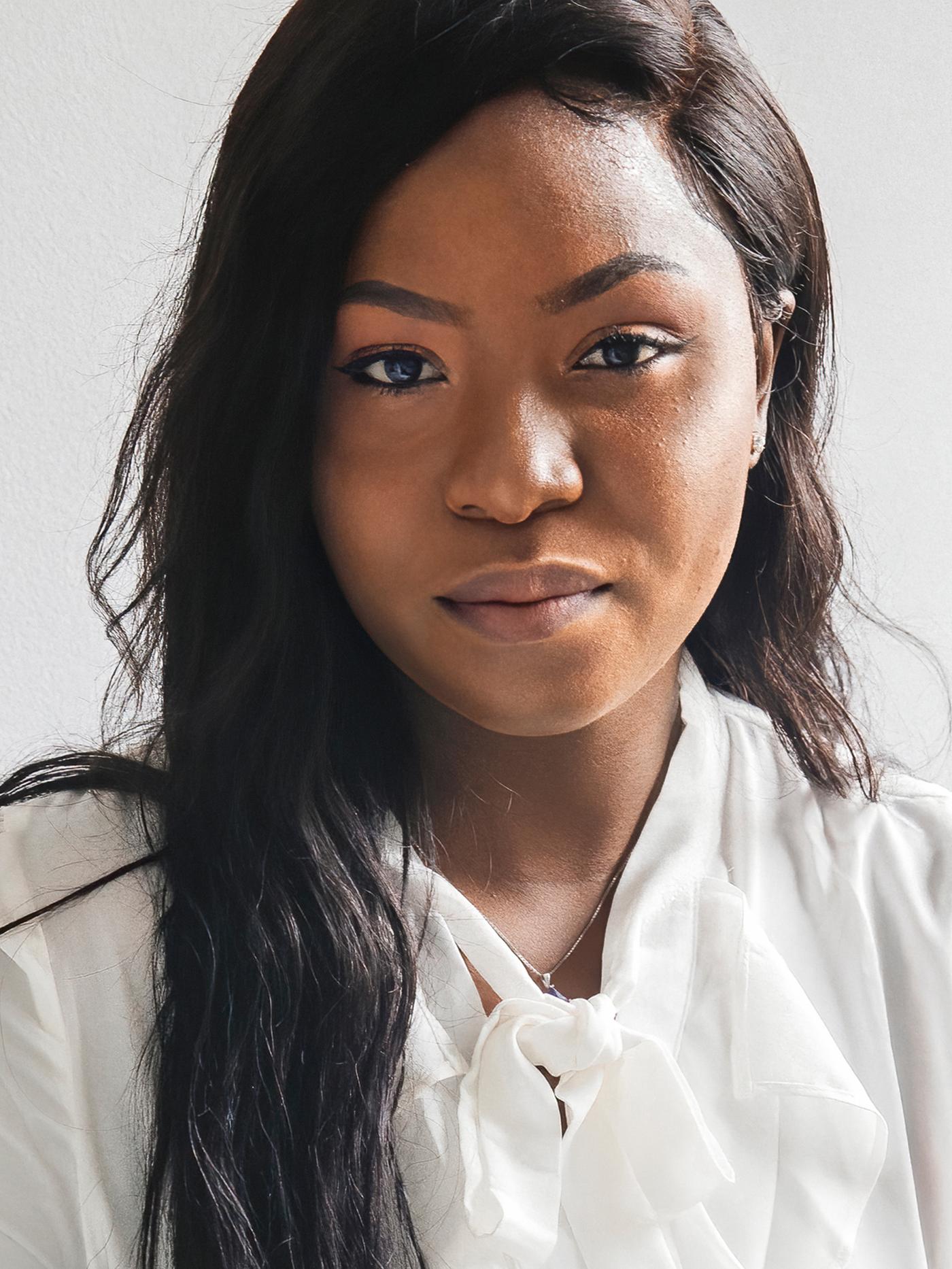 Portret van Precious, een Nigeriaanse vluchtelinge die bij IKEA Canada werkt, met witte top.