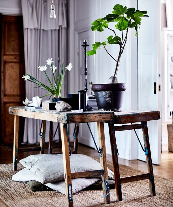 Potted plants and stones on rustic wooden benches.