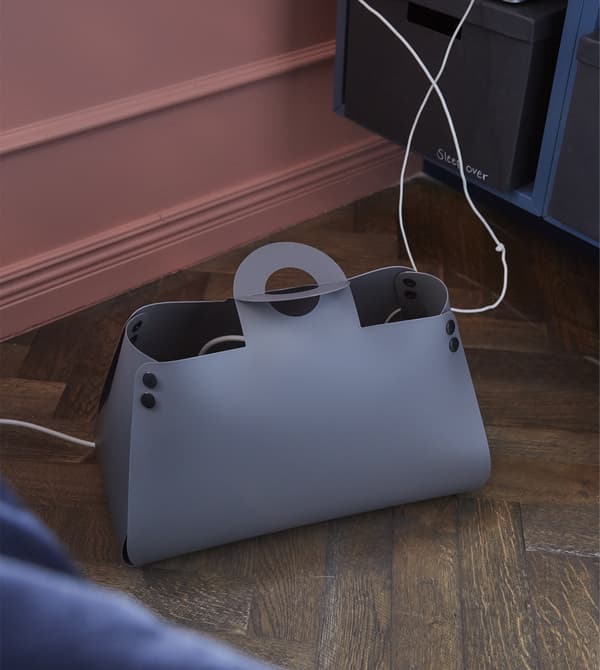Pour créer un séjour accueillant et chaleureux pour vous et vos amis, prévoyez un endroit pour recharger les téléphones. Comme le sac de gestion des câbles IDEBO de chez IKEA. Il cache les câbles dans un sac en plastique épais qui ressemble à un sac à main.
