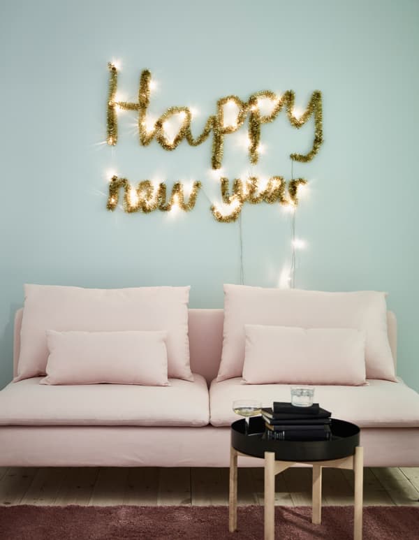 Pour votre décoration murale, utilisez par exemple une guirlande lumineuse LED SÄRDAL et une guirlande dorée IKEA. Branchez la guirlande lumineuse pour faire ressortir votre mantra du nouvel an. Enroulez la guirlande autour des lumières pour que votre message brille non stop.