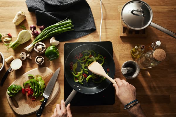 Préparation d’un repas coloré à l’aide de la table de cuisson mobile TILLREDA.