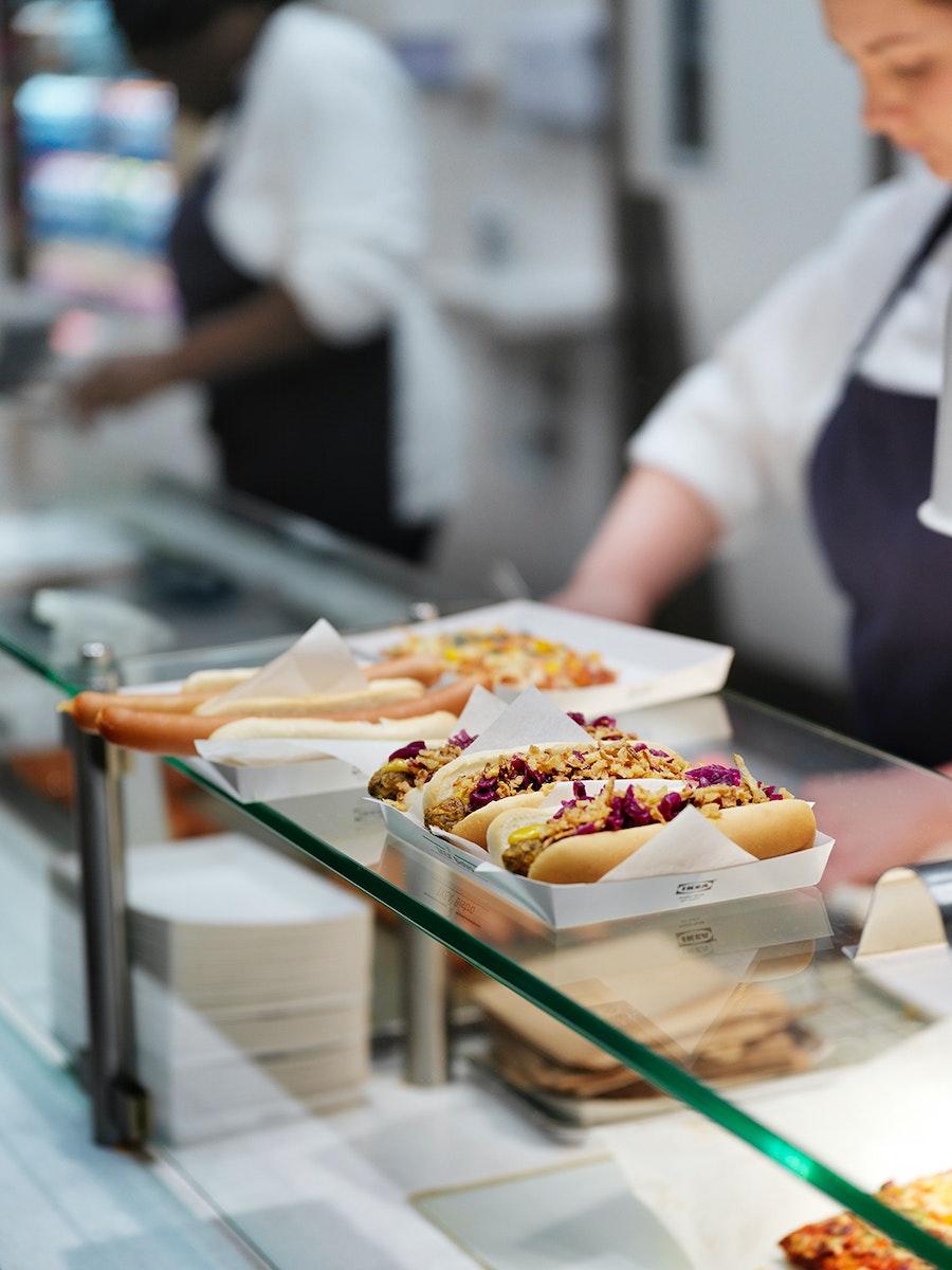 Prikaz hot-dogov v bistroju IKEA na polici steklene vitrine v Švedskem bistroju.