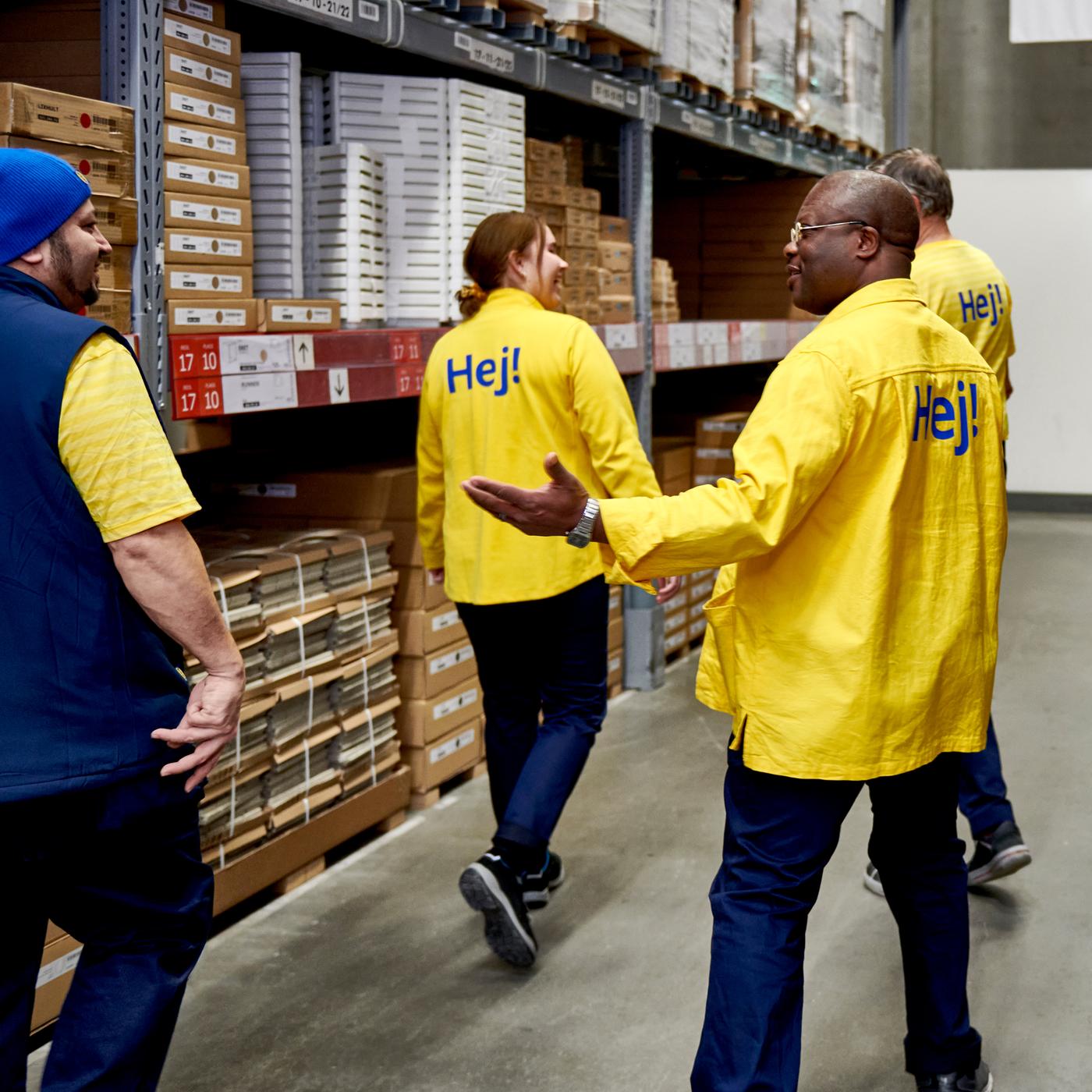 Quatre collaborateurs IKEA, dont trois portent des vestes jaunes et un porte un gilet bleu, dans la zone Libre-service d’un magasin IKEA. 