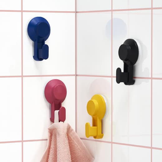 Quatre crochets à ventouse colorés fixés aux carreaux