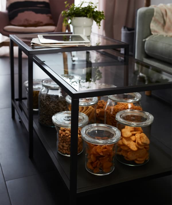 Quelques grands bocaux remplis de divers snacks, sur le plateau inférieur d'une table gigogne VITTSJÖ.