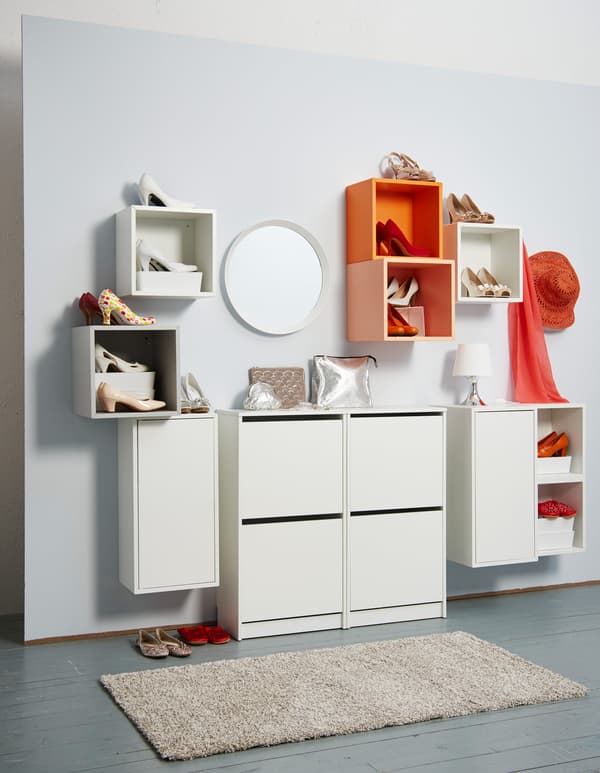 Rangements ouverts orange et blancs pour les chaussures à talons et rangements fermés blancs pour les autres chaussures.