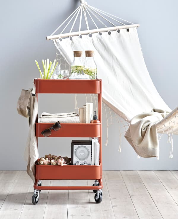 RÅSKOG trolley being used for carrying drinks, books and music for relaxing.