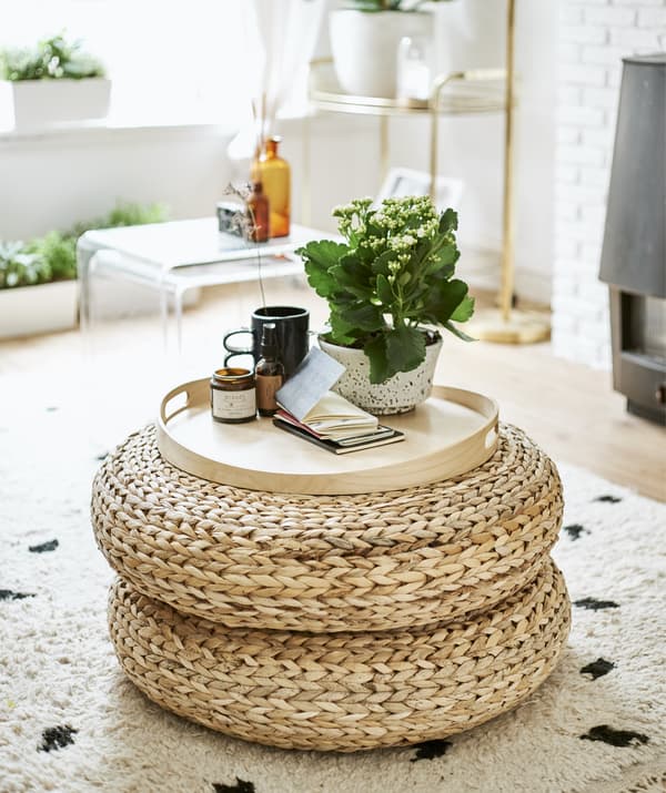 Rattan footstools stacked and used as a side table.