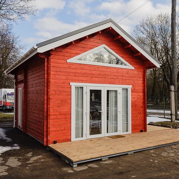 Red wooden tiny house exterior with white trim and front porch