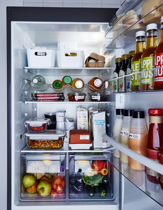 Réfrigérateur bien ordonné et aliments rangés dans des contenants transparents ou étiquetés.