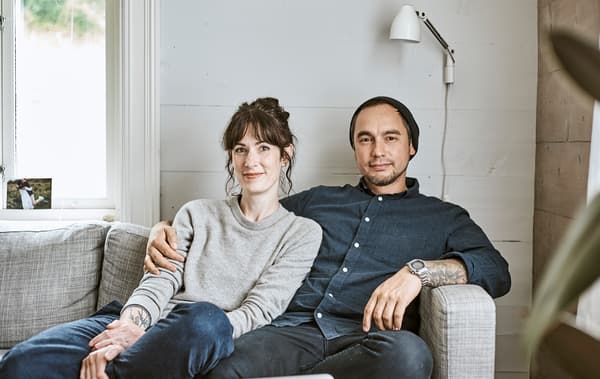 Rena et Sam assis sur leur canapé dans leur ferme norvégienne.