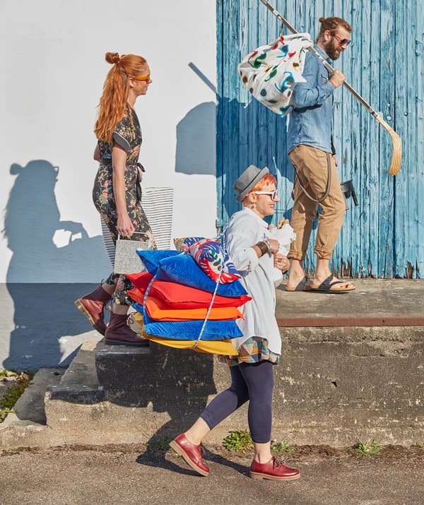 Rendez-vous à une fête d’été en plein air avec des coussins et le tissu multicolore SOMMAR 2019 comme couverture.