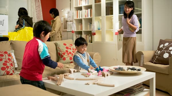リビング風のスペースで子どもたちが木製おもちゃで遊んでいる。