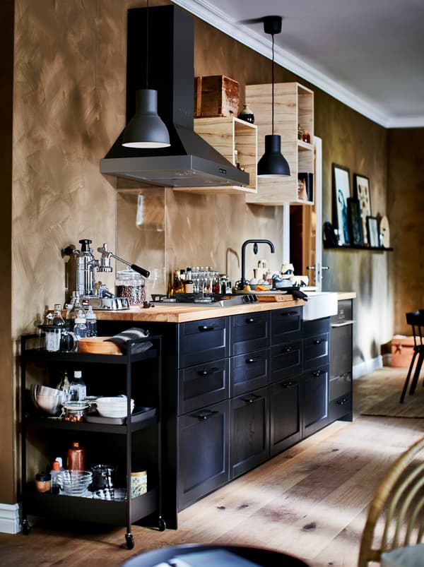 Richly equipped kitchenette with small, open wall cabinets, kitchen fan, and dark LERHYTTAN drawer fronts.