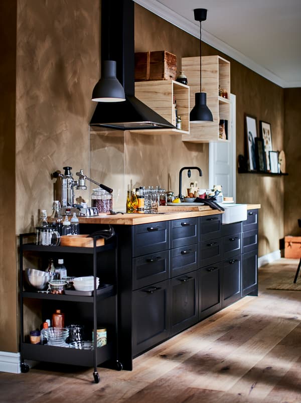 Richly equipped kitchenette with small, open wall cabinets, kitchen fan, and dark LERHYTTAN drawer fronts.