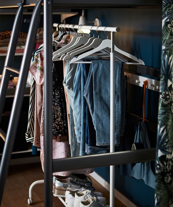 RIGGA clothes rack with hangers and clothes. It is adjustable in height and has four castors.