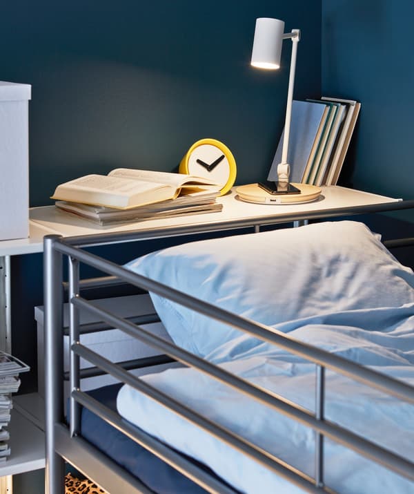 RIGGAD work lamp illuminating a sleeping area and charging a smartphone.