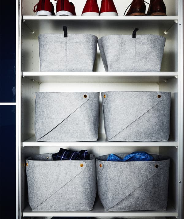 Ripiani rettangolari di un guardaroba occupati da cestini grigi in feltro, una fila di scarpe sul ripiano superiore - IKEA