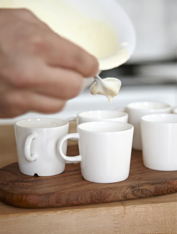 Rober decants the mixture for lemon mousse into espresso cups.