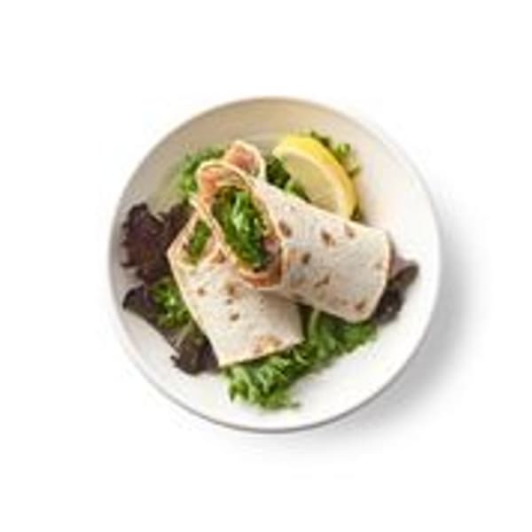 Rollito de salmón marinado, servido en un pan plano integral con verduras variadas