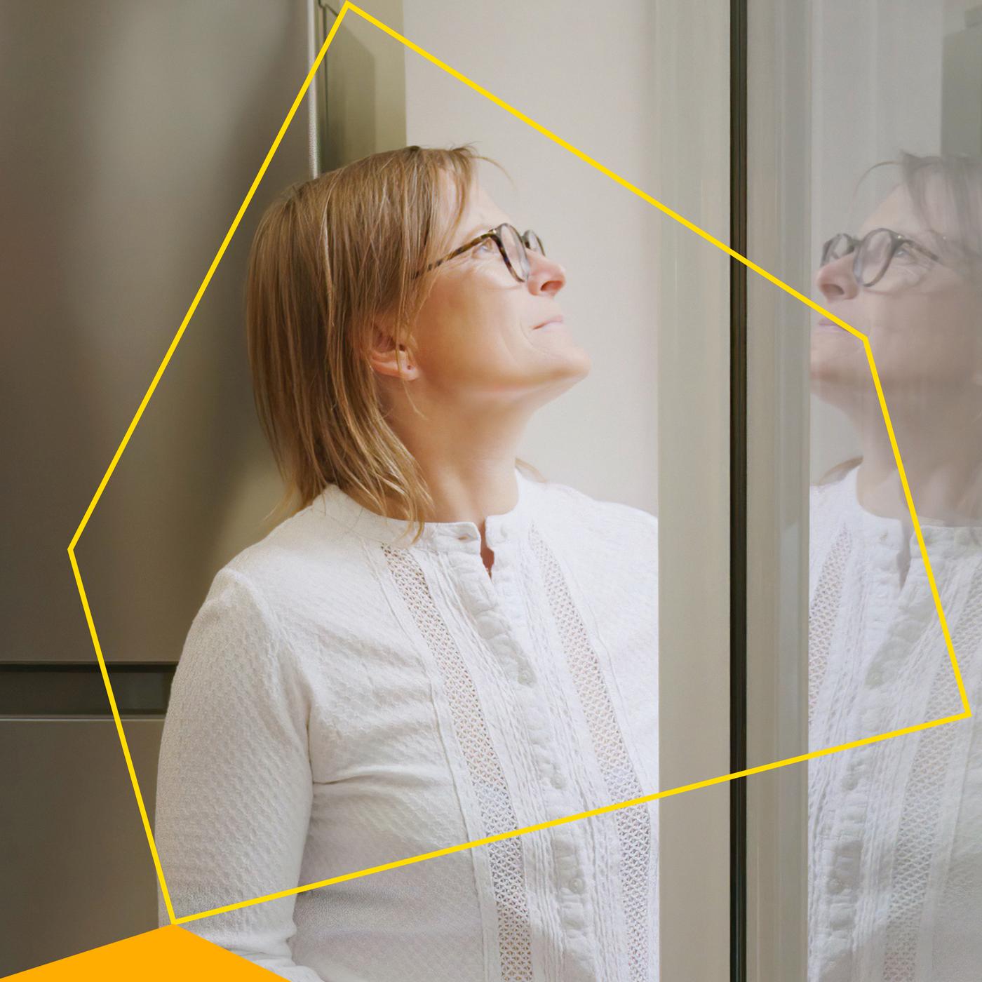 رسم لمخطط منزل أصفر يظهر على امرأة تنظر من نافذة منزلها.