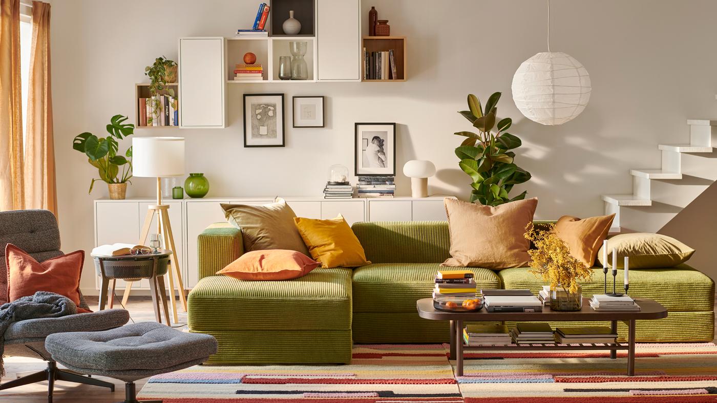 Ruang tamu yang cerah yang berpusat pada sofa tiga tempat duduk setengah dengan chaise longue JÄTTEBO dan kabinet lekap dinding EKET.