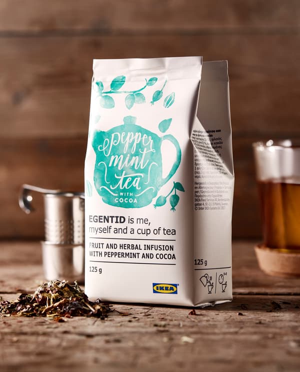 Sac de tisane EGENTID placé sur un plan de travail en bois et entouré d’une trousse de préparation de thé et d’une tasse à thé.