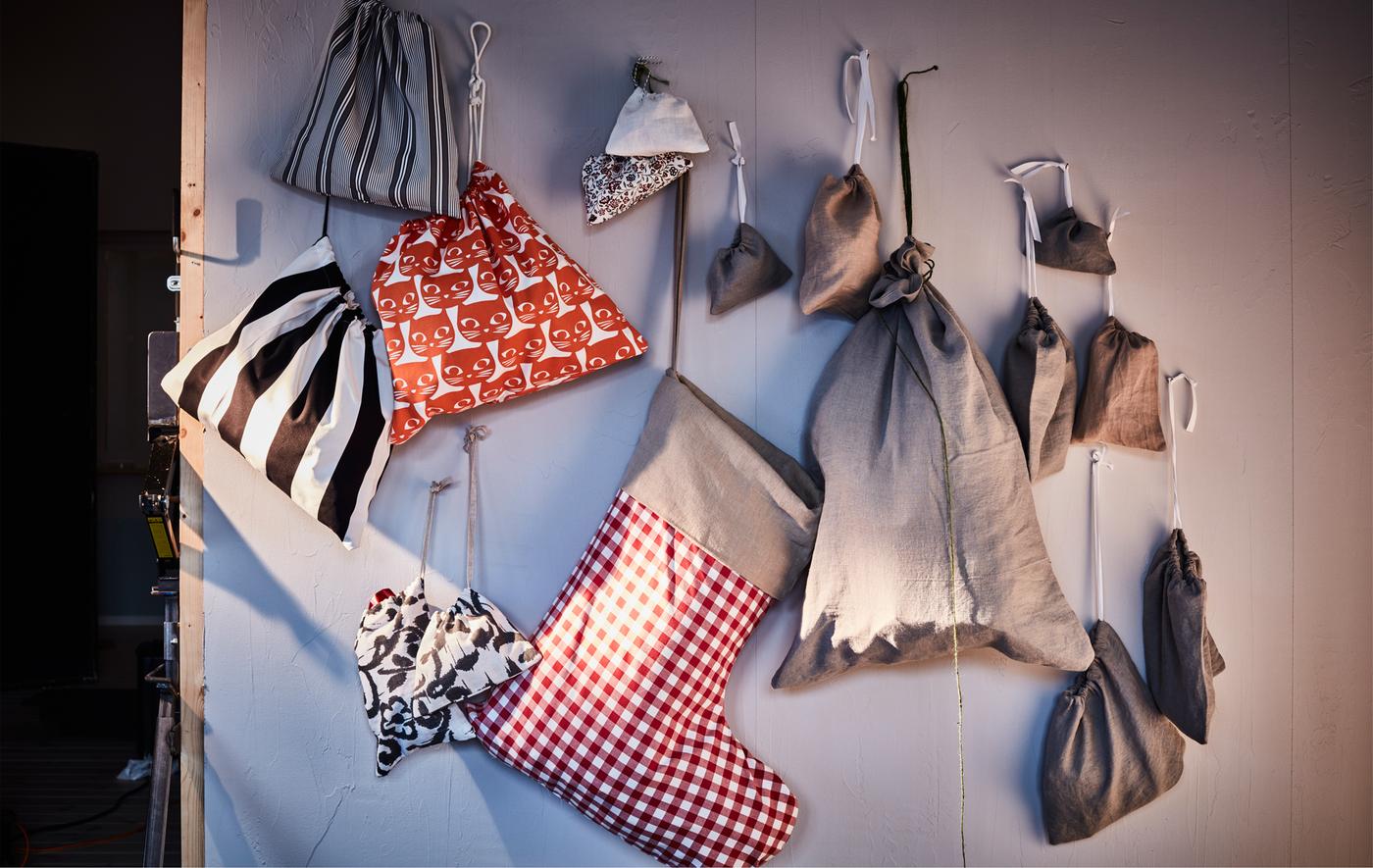 Sacs et pochettes à cadeaux de taille différentes accrochés au mur.