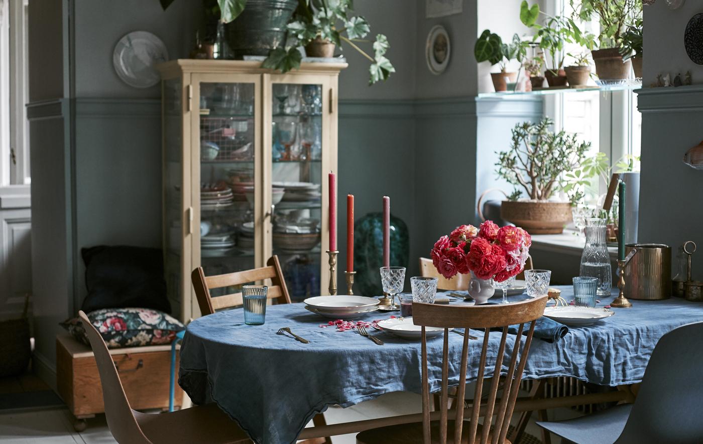 Salle à manger avec couverts, verres, chaises et coussins.