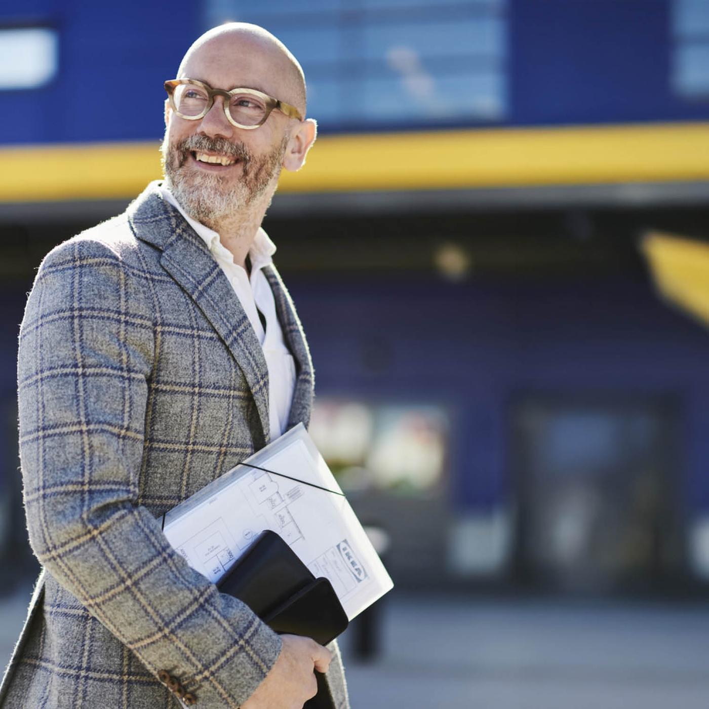 Satisfied customer smiling in front of an IKEA store.