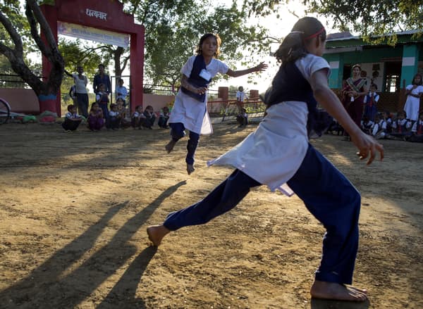Scène d'une soirée en plein air dans un pays d'Orient où des filles courent dans la cour d'école.