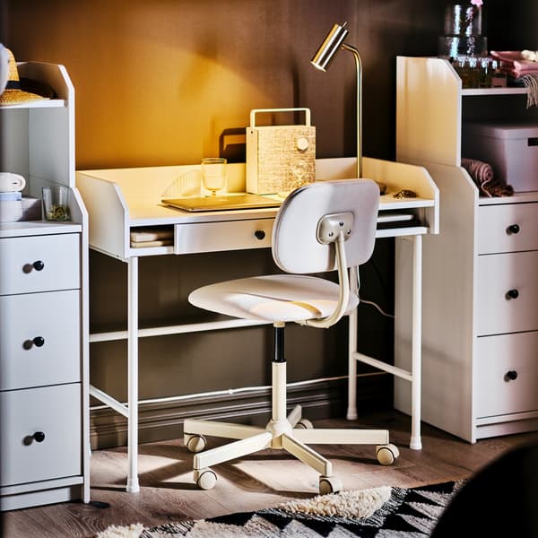 Scrivania HAUGA bianca e una sedia girevole beige tra due cassettiere HAUGA con 3 cassetti e mensola.