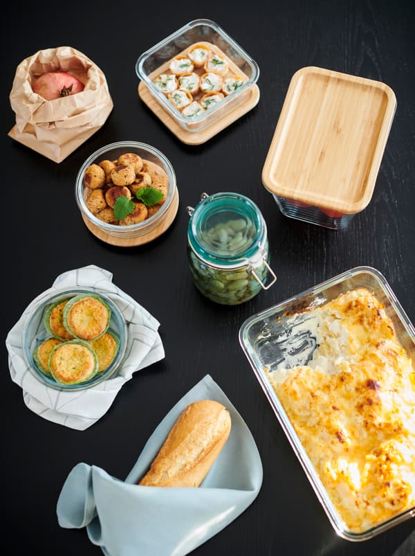 Section of a table with a mix of jars, an oven dish and IKEA 365+ food containers, all filled with different dishes.
