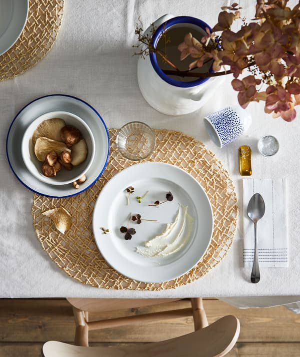 Section of dining table with an artful setting for one, including coordinated colours, shapes and decorations.