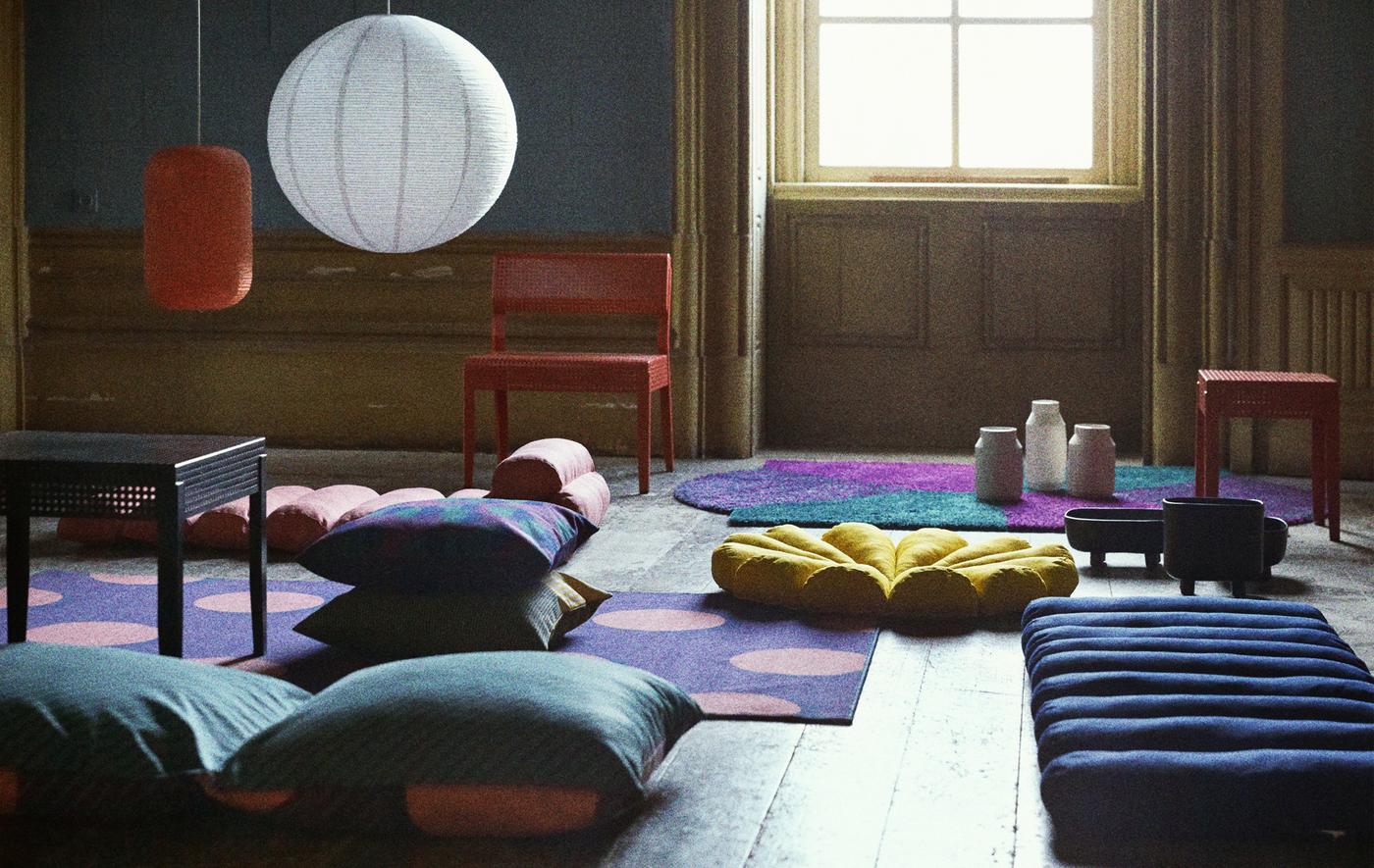 Séjour avec coussins et tapis aux motifs lumineux, éparpillés sur le sol.