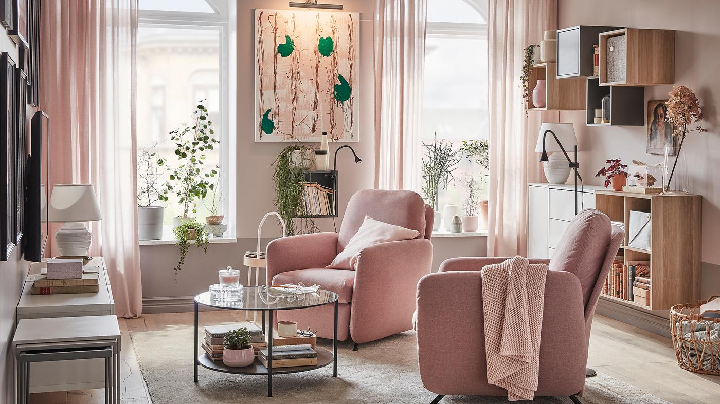 Séjour avec deux fauteuils confort EKOLSUND dans des housses GUNNARED brun clair-rose, devant des fenêtres où la lumière afflue.