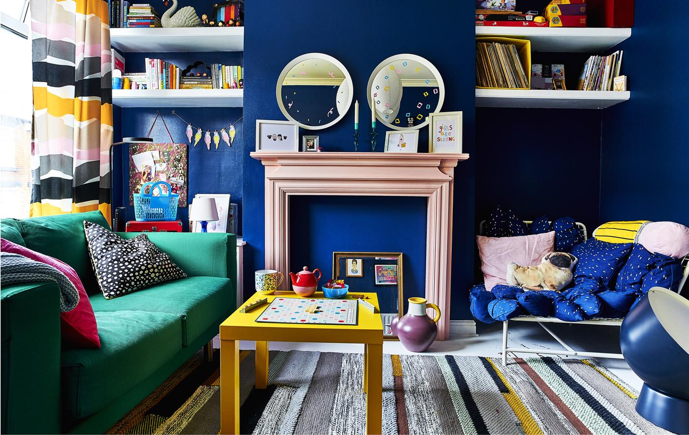 Séjour coloré avec murs bleus et canapé vert.
