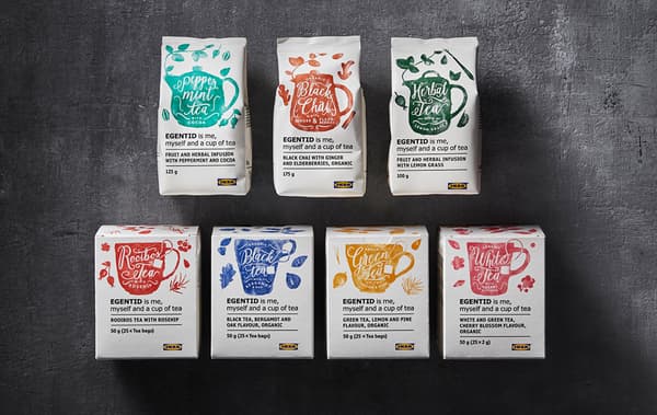 Sept paquets blancs avec des illustrations colorées de différentes variétés de thés et du thé sur une surface foncée.