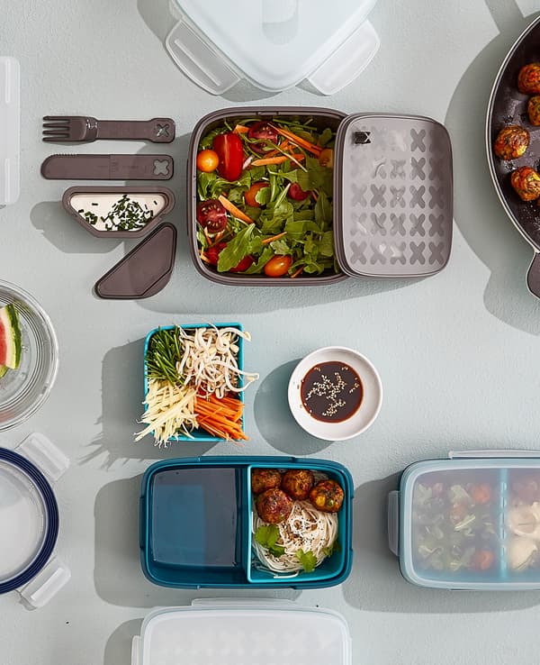 Several lunch boxes on a worktop showing options for removable compartments for separating food types.