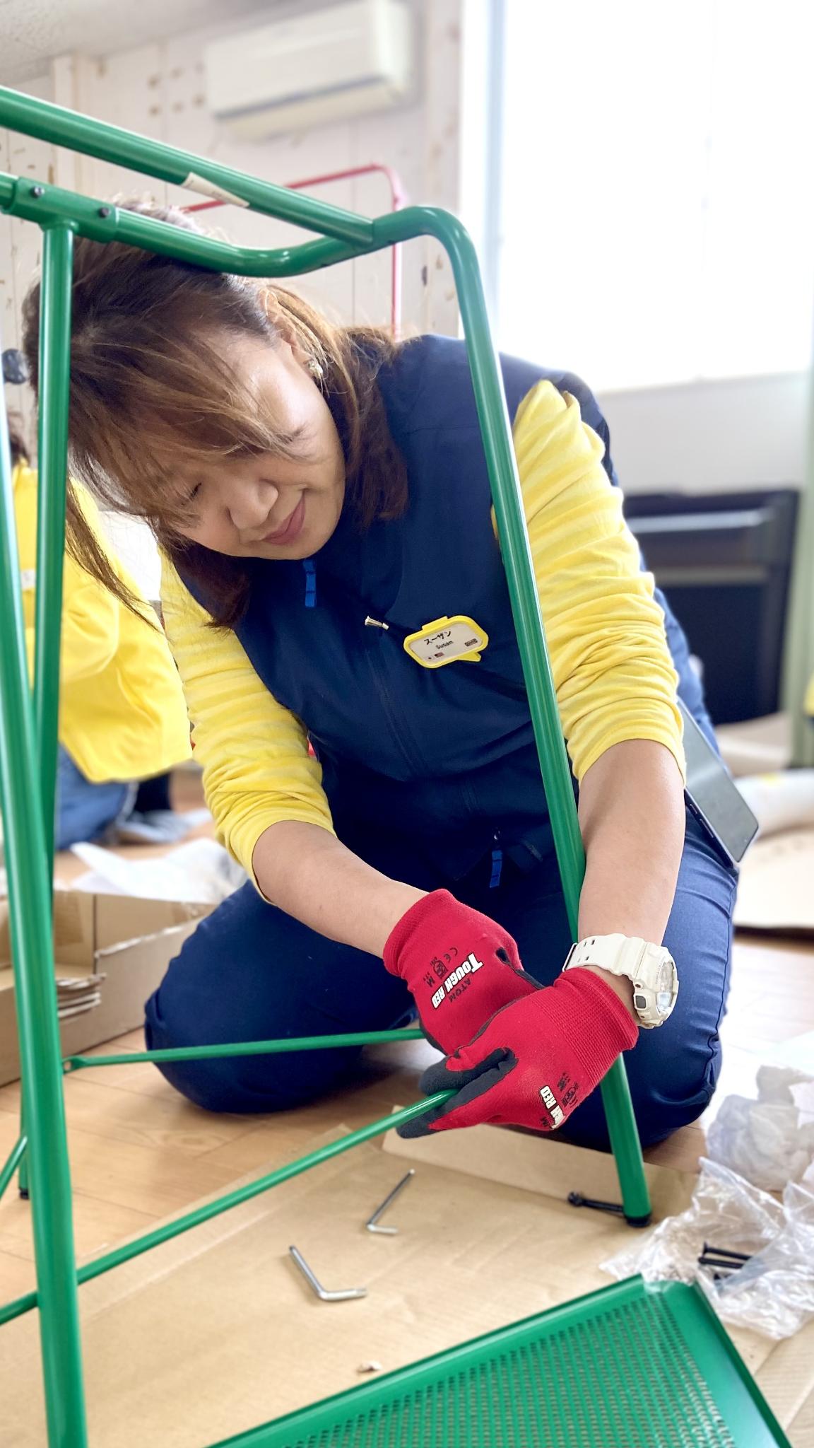 しゃがんで家具を組み立てるイケアスタッフ