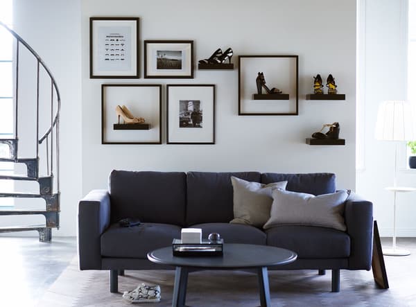 Shoes sit on shelves and in frames on a wall in this living room, making them decoration as well as footware.