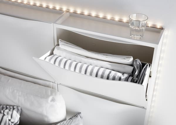 Six armoires à chaussures IKEA TRONES blanches utilisées pour créer une tête de lit.