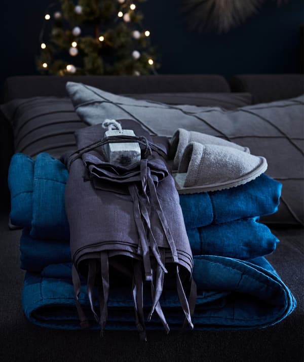 Slippers perched on top of an IKEA PUDERVIVA quilt cover and pillowcase.