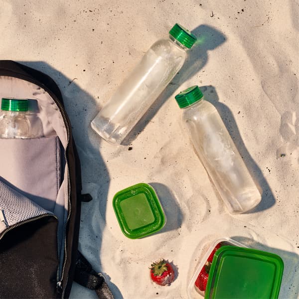 Small food storage containers and water bottles are unpacked from a backpack.