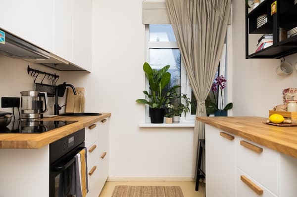 Small linear kitchen with wooden worktop, built-in appliances and a window.