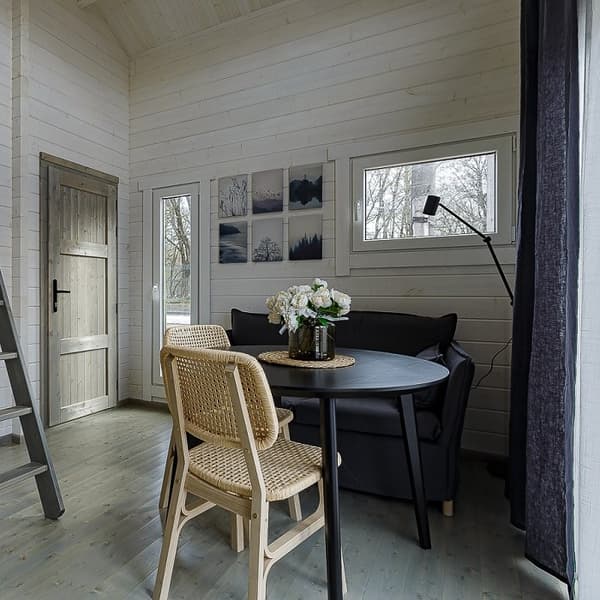 Small living area with black sofa, dining table, and wall art