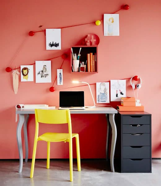 Small workspace with a grey desk, yellow chair and black drawer unit