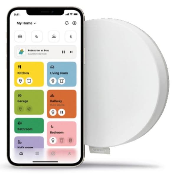 Smartphone où est ouverte l’appli IKEA Home smart, à côté d’un lanceur de scénario intelligent TRÅDFRI et d’un hub DIRIGERA.