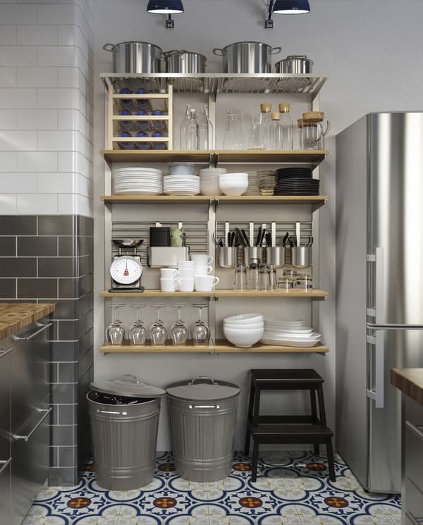 Solution de rangement mural avec étagères en bois, récipients, rails, tablettes, grilles, etc. qui accueille de nombreux articles de cuisine.