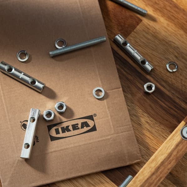 Some screws and small IKEA spare parts on an IKEA shipping box.